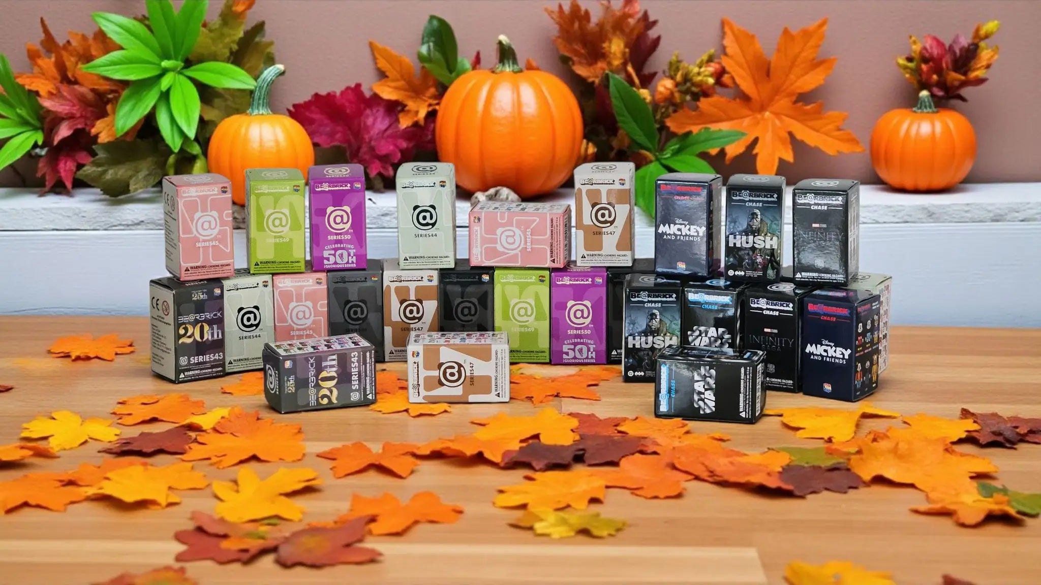 Ein Arrangement von Bearbrick-Blindboxen in herbstlichem Setting
